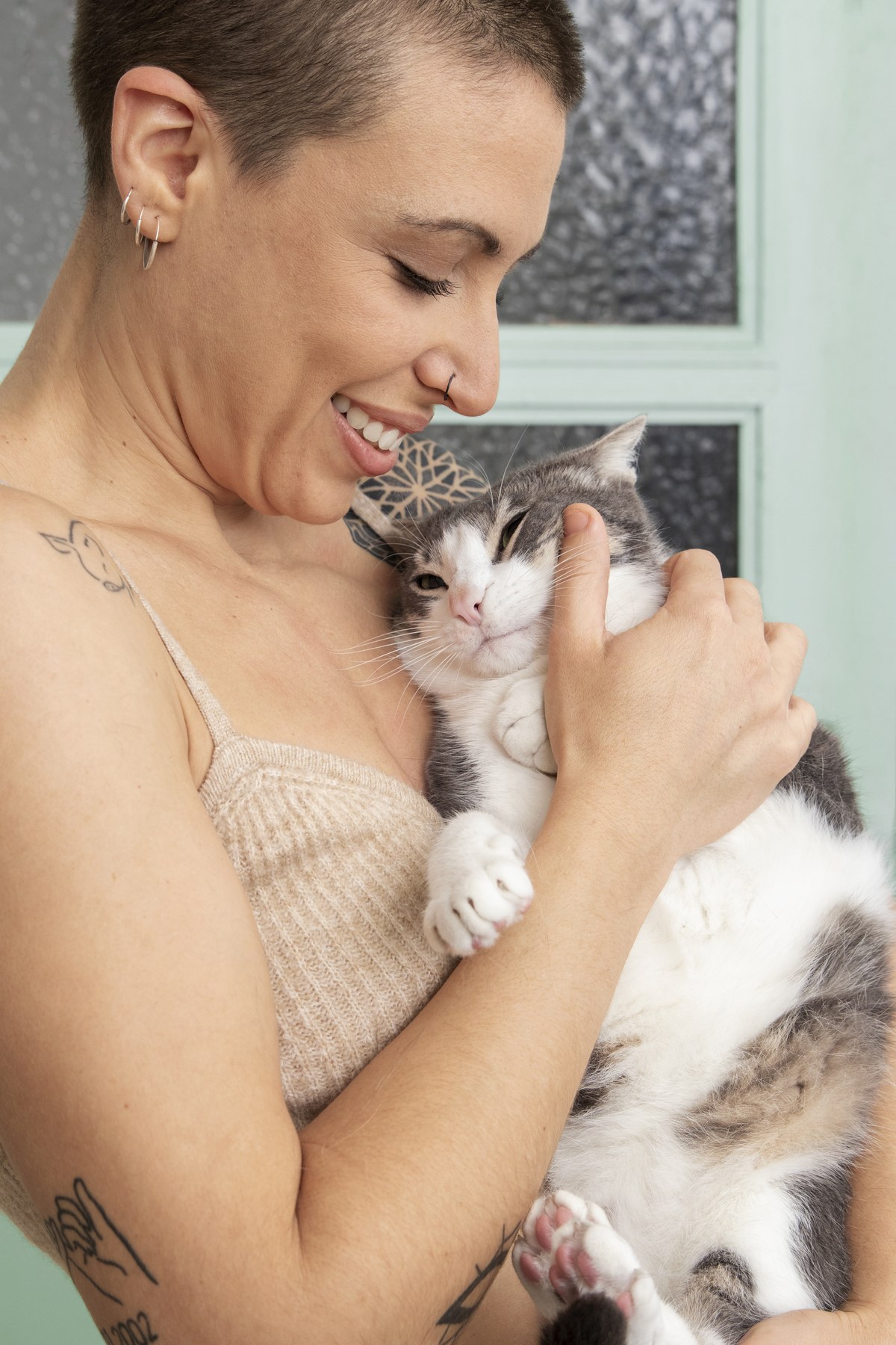 Mujer sujetando un gato con ternura en su casa